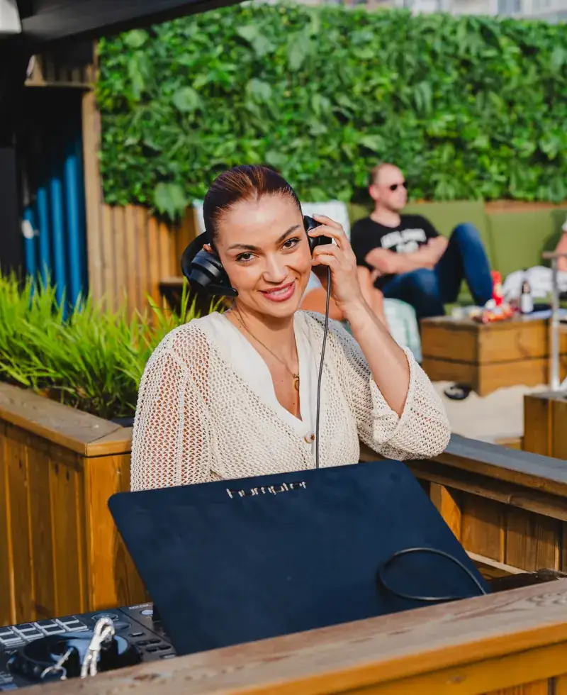 DJ met koptelefoon draait op het terras