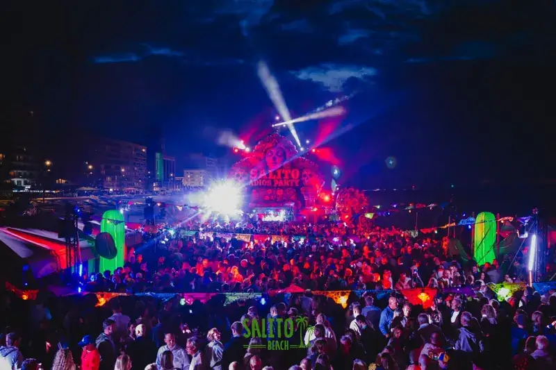 Lasers boven een volle dansvloer op het strand