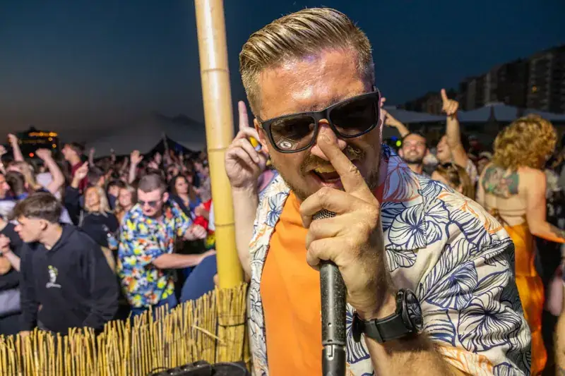 Zanger met zonnebril en microfoon op het podium